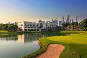 迪拜迪拜蒙哥马利地标酒店的一座高尔夫球场,在一座建筑前设有一个池塘