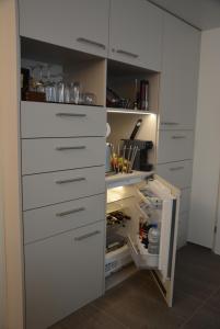 SirnachBnB Sirnach的厨房配有白色橱柜和开放式冰箱。