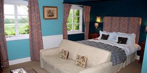 Leintwardine罗尔巴克顿乡间别墅酒店的一间卧室配有一张床、一张沙发和窗户。