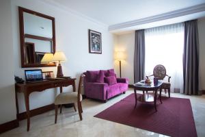 雅加达Arion Suites Hotel Kemang的客厅配有紫色沙发和桌子