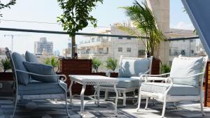内坦亚Luxury Rooftop Apartment in Netanya的阳台上的一组椅子和一张桌子