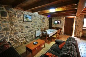 O PindoCasa Porto de Quilmas的客厅配有桌子和石墙