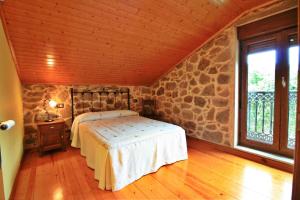 O PindoCasa Porto de Quilmas的一间卧室设有一张床和石墙