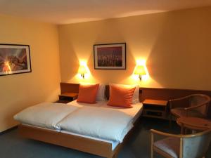 欧博比皮Hotel Eintracht的酒店客房,配有一张带两盏灯和两把椅子的床
