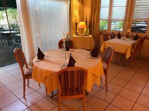 欧博比皮Hotel Eintracht的一间用餐室,配有两张带黄桌布的桌子