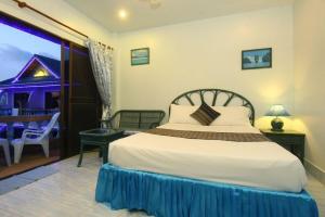 芭东海滩Patong Sunbeach Mansion的一间卧室配有一张床,另一间设有阳台。