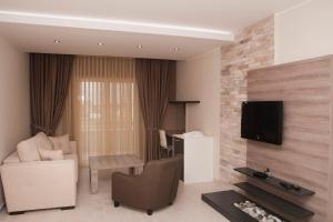 乌尔齐尼拉古纳酒店的客厅配有沙发和墙上的电视
