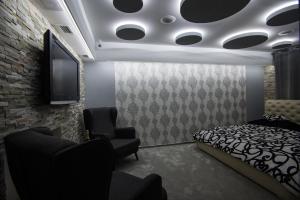 捷克捷欣Wellness Apartmán Relax的一间卧室配有一张床和一台平面电视