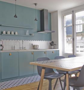 圣马洛Appartement de charme的厨房配有蓝色橱柜和桌椅