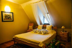 PirčiupiaiPirčiupio Karčema的一间卧室设有一张黄色墙壁和窗户的床