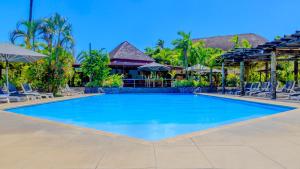 阿皮亚塔诺阿图斯塔拉酒店的度假村的游泳池,配有椅子和遮阳伞