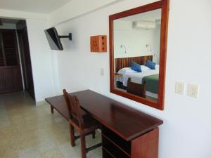 巴亚尔塔港罗西塔酒店 的一间卧室配有书桌、镜子和床