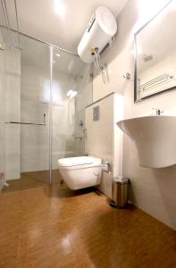新德里爱玩夏希酒店 的浴室配有卫生间、淋浴和盥洗盆。