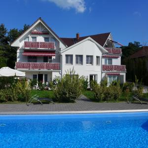 巴拉通尤洛克阿斯托利亚别墅住宿加早餐旅馆的一座白色的房子,前面设有一个游泳池