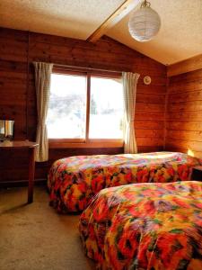 妙高Yado Brodiaea的一间卧室设有两张床和窗户。