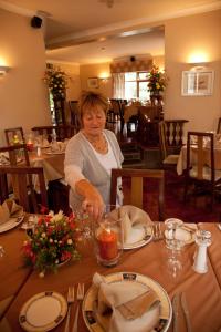 Ballymacarbry哈诺拉小屋旅馆及餐厅的坐在餐厅桌子上的女人