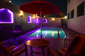 安曼拉尔萨酒店的一个带桌子和遮阳伞的游泳池