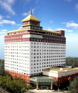 成都成都西藏饭店（尊享欢迎藏茶礼遇）的一座白色的大建筑,上面有一座塔