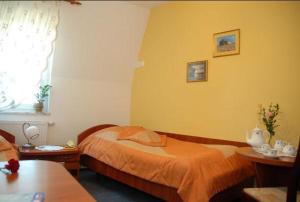 沃尔什滕考卡斯酒店的一间卧室设有床、两张桌子和一扇窗户