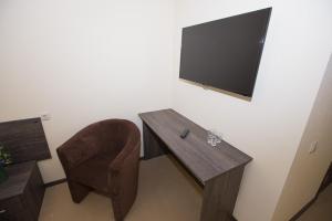 喀山加加恩旅馆酒店的配有桌子、椅子和电视的房间
