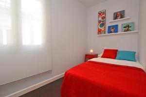 阿利坎特Ático con terraza en el centro de Alicante的一间卧室配有红色的床和红色毯子