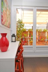 阿利坎特Ático con terraza en el centro de Alicante的红色的花瓶坐在房间里