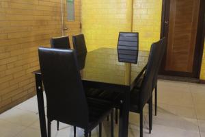 马累公园之家旅馆的餐桌周围摆放着黑色椅子
