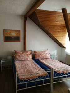 爱尔福特Pension Harmonie的卧室设有两张床铺和木制天花板