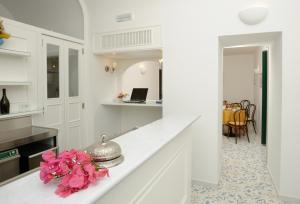 拉维罗艾尔杜卡托蒂拉维洛酒店的厨房配有白色橱柜和粉红色的花朵