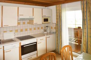 弗拉绍Ferienhaus Steger Maria的厨房配有白色橱柜和桌椅