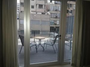 科尔多瓦Olmos Suites的阳台配有桌椅,享有风景。
