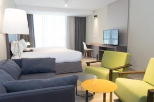 科尔多瓦Olmos Suites的酒店客房配有一张床、一张沙发和椅子。