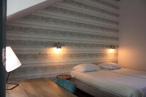GemertHotel De Hoefpoort的一间卧室设有两张床和木墙