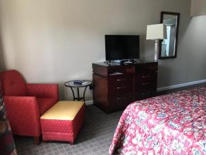 中心城市CCI Express Inn的酒店客房配有一张床、一把椅子和一台电视。