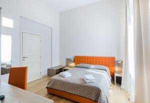 佛罗伦萨VRooms All'Angolo Del Duomo的一间卧室配有橙色的床和桌子