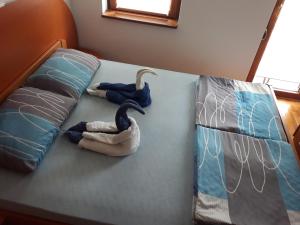 弗尔尼亚奇卡矿泉镇Apartment Hedonic的两个天鹅坐在床上,床上有枕头