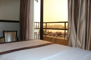 迪拜埃尔卡里大酒店的一间卧室设有一张床和一个大窗户