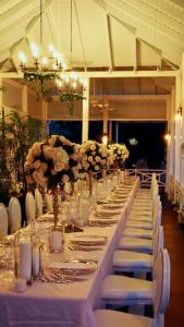 金斯敦利瓜尼亚俱乐部酒店的长长的桌子,带白色椅子和鲜花