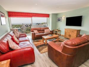 索尔瓦Harmon Vale的客厅配有皮革家具和平面电视