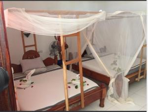 南威Ebony & Ivory Beach Bungalows的客房内的双层床(带天蓬)