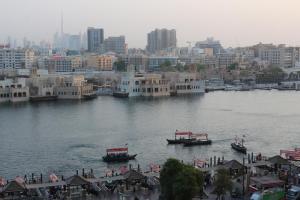 迪拜埃尔卡里大酒店的两艘船在河里,以城市为背景