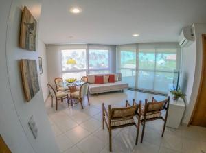 普拉亚多斯卡内罗斯Carneiros Beach Particular Flat的客厅配有沙发和桌椅