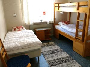 Laisvall斯道博恩斯图甘山林小屋的一间卧室设有两张双层床和一扇窗户。