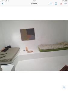 阿索马达Patio II studio at finca的一间设有两张床的客房,墙上挂有绘画作品