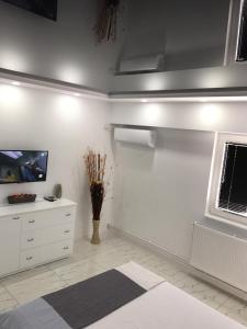 加拉茨Archi's Apartament的一间白色客房,配有电视和梳妆台