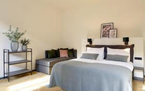 马里博尔Hotel Maribor & Garden Rooms的一间卧室配有一张床和一张沙发