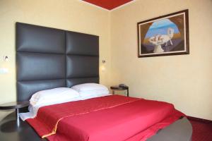 利尼亚诺萨比亚多罗索拉亚酒店的一间卧室配有一张大床和黑色床头板