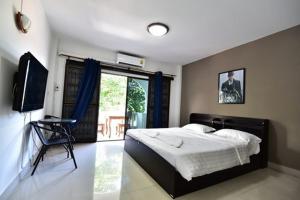 乔木提恩海滩Escobar Guesthouse的一间卧室设有一张床、一台电视和一个窗口。