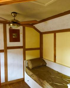 格拉斯顿伯里The Rabbit Hole的配有吊扇的客房内的一张床位