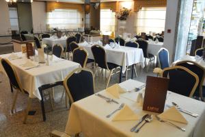 安曼卡普里酒店的用餐室配有桌椅和白色桌布